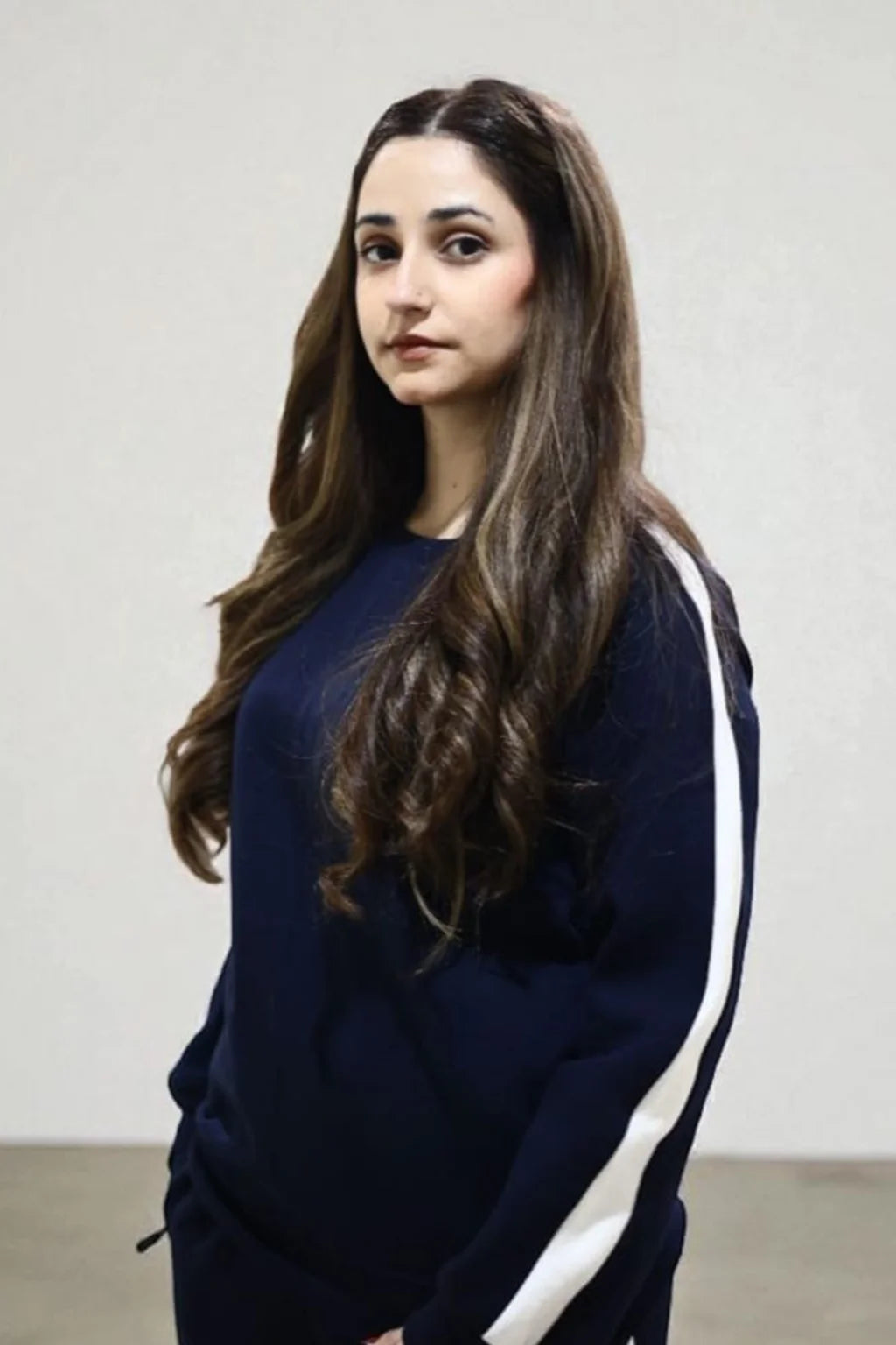 Close-up view of Model wearing Blue sweatshirt with white stripes