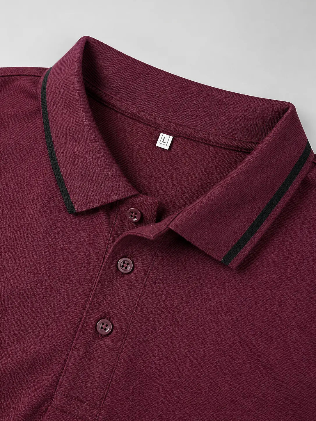 Maroon polo shirt with black trim on a light gray background