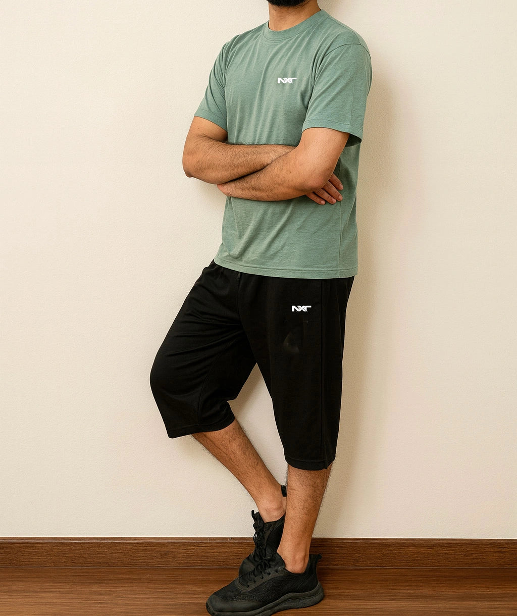 Side pose of Men wearing Nxt logo Tee in green and shorts in black color