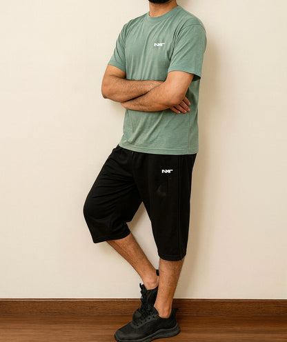 Side pose of Men wearing Nxt logo Tee in green and shorts in black color