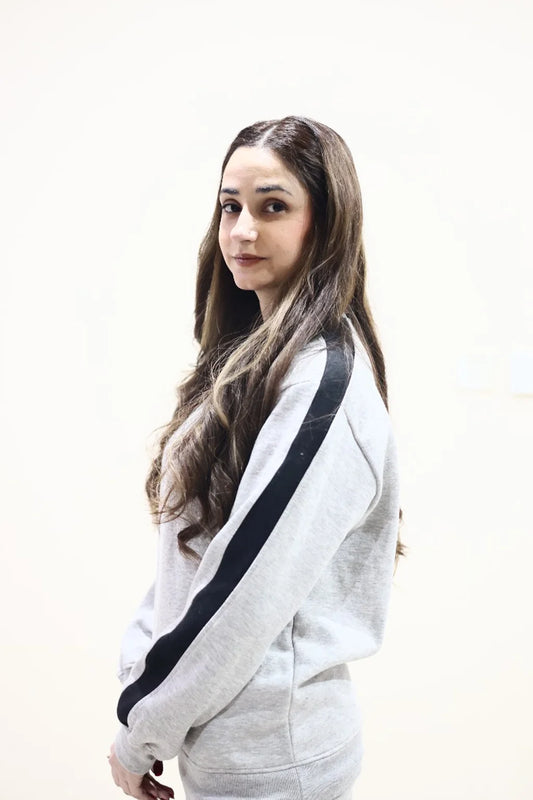 Side view of model wearing heather Grey Sweatshirt with black stripes on arm 