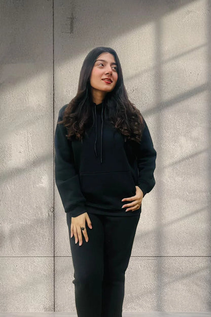 Women wearing a black Pullover Hoodie and Jogger pants posing for front view with studio plain background