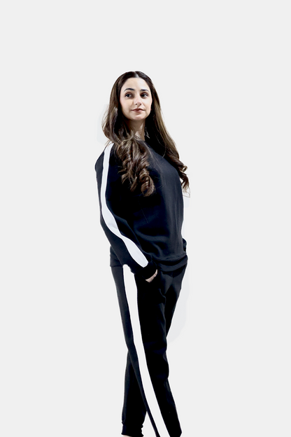 Tilted view of female model wearing black tracksuit with white stripes in premium quality
