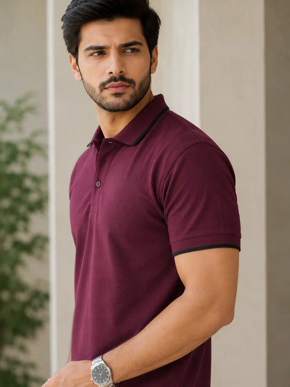 Man wearing a maroon polo shirt with black trim against a neutral background
