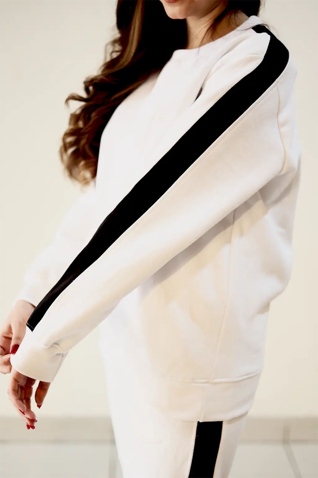 Close-up of Arm black stripe border detailing on White fleece winter sweatsuit
